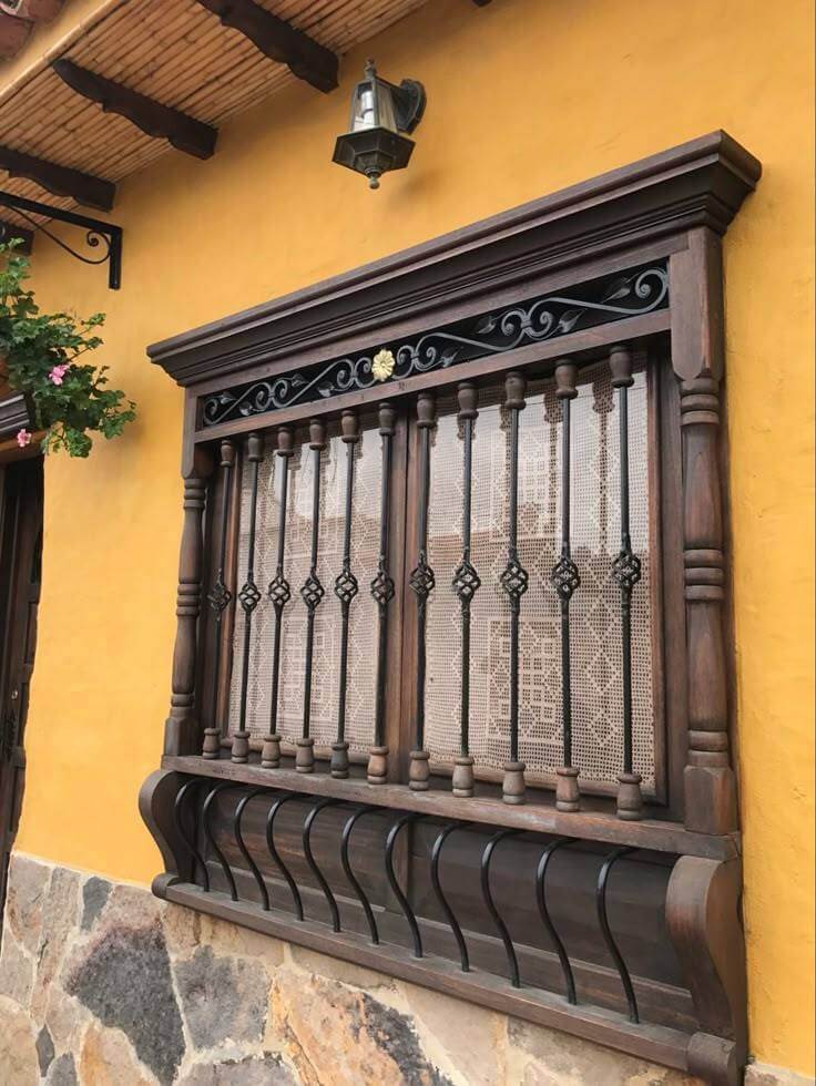Rejas de hierro forjado con detalles en madera, combinando seguridad y estilo en la ventana.