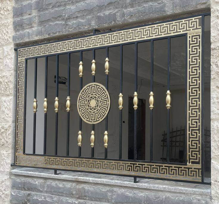Rejas de hierro forjado con detalles dorados y patrón geométrico, proporcionando seguridad y un diseño sofisticado a la ventana.