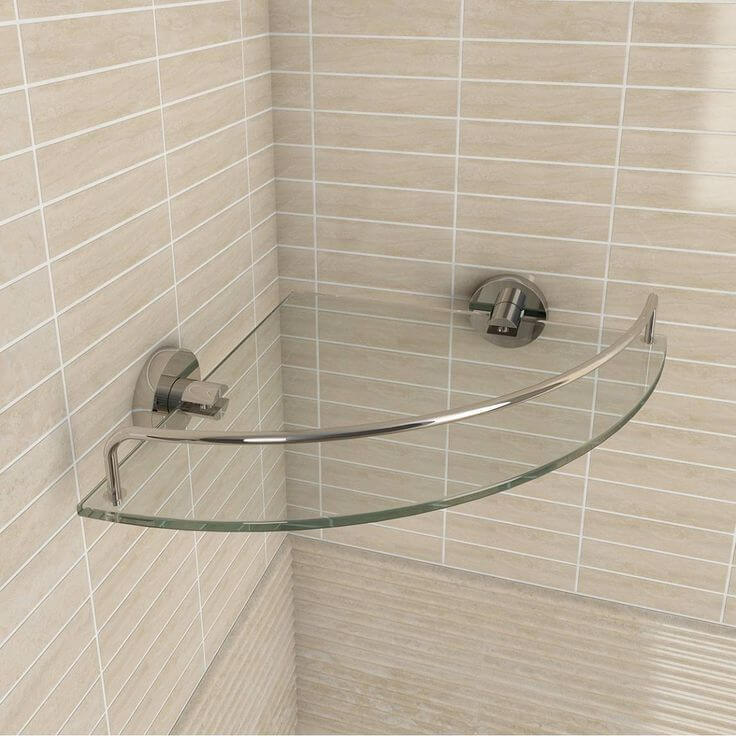 Repisa de cristal curvada en baño con soporte metálico. Diseño moderno y funcional para aprovechar el espacio.