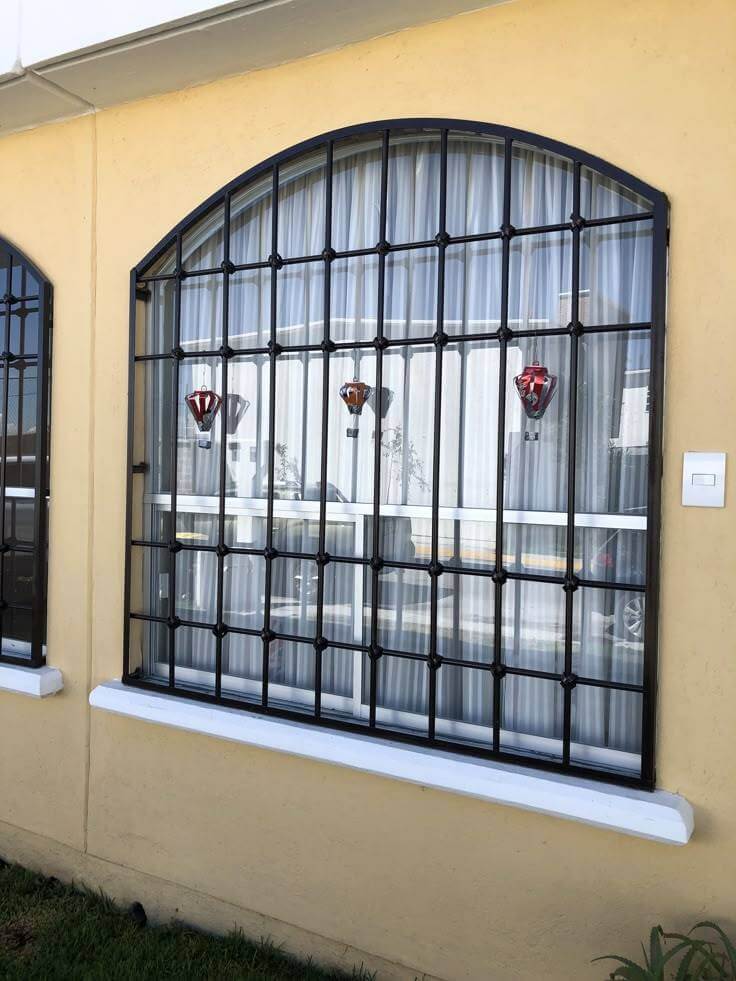 Rejas de hierro forjado con diseño sencillo y elegante, ideal para proporcionar seguridad sin obstruir la vista. Perfectas para ventanas arqueadas con un toque minimalista.