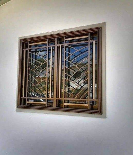 Rejas de hierro forjado con un diseño geométrico moderno, enmarcadas con detalles en madera, combinando seguridad y estilo contemporáneo para la ventana. Perfectas para ambientes modernos y sofisticados